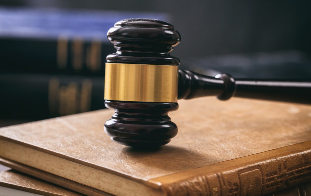 Judge gavel on law books, wooden desk